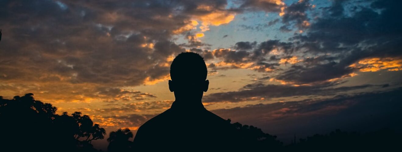 silhouette of man watching golden hour