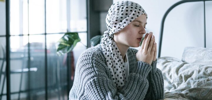 woman in gray knit sweater praying