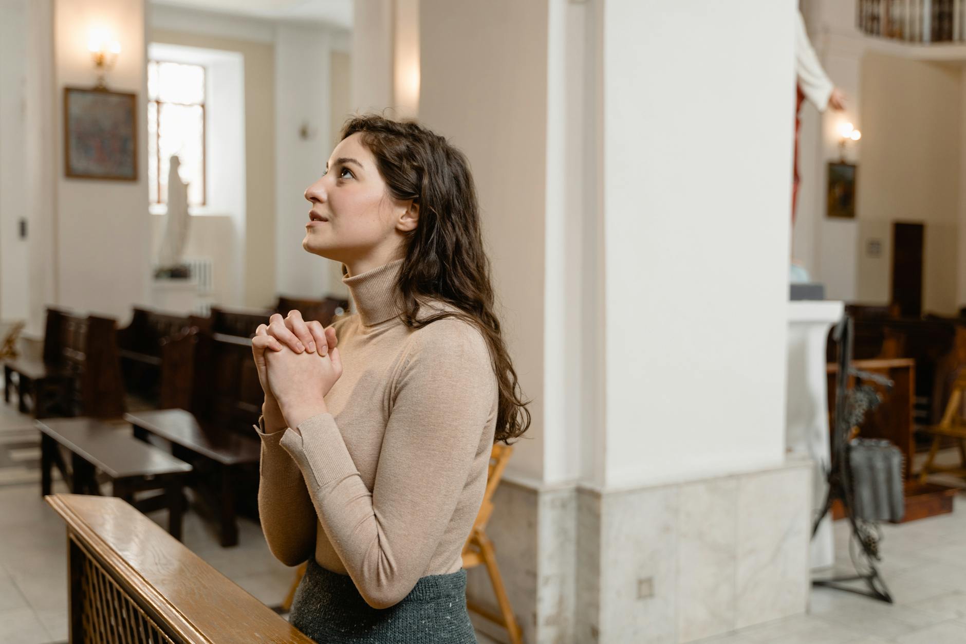 woman in a brown long sleeve shirt praying